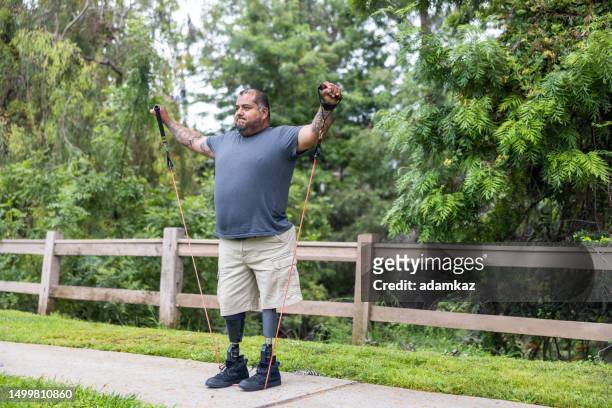 disabled hispanic veteran working out with resistance bands - amputee rehab stock pictures, royalty-free photos & images