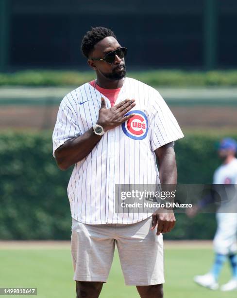 Retired Chicago Bears cornerback Charles "Peanut” Tillman throws the ceremonial first pitch of the game between the Chicago Cubs and the Baltimore...