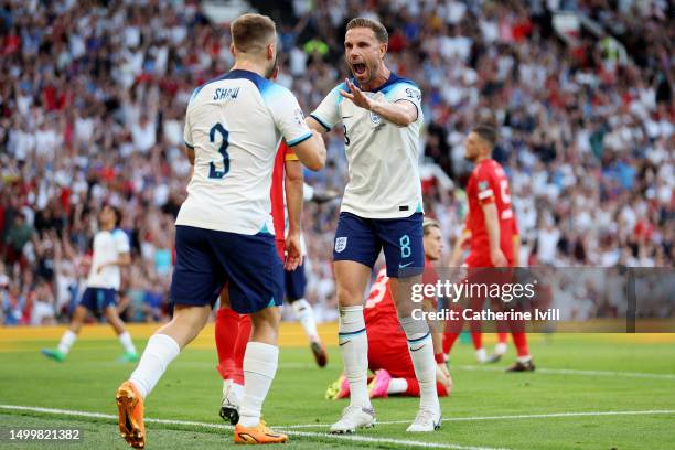 Luke Shaw and Jordan Henderson of England celebrate their team's first goal during the UEFA EURO 2024 qualifying round group C match between England...