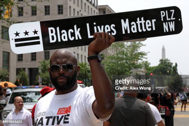 Man holds up a sign of Black Lives Matter Plaza during a Juneteenth celebration event at Black Lives Matter Plaza on June 19, 2023 in Washington, DC....