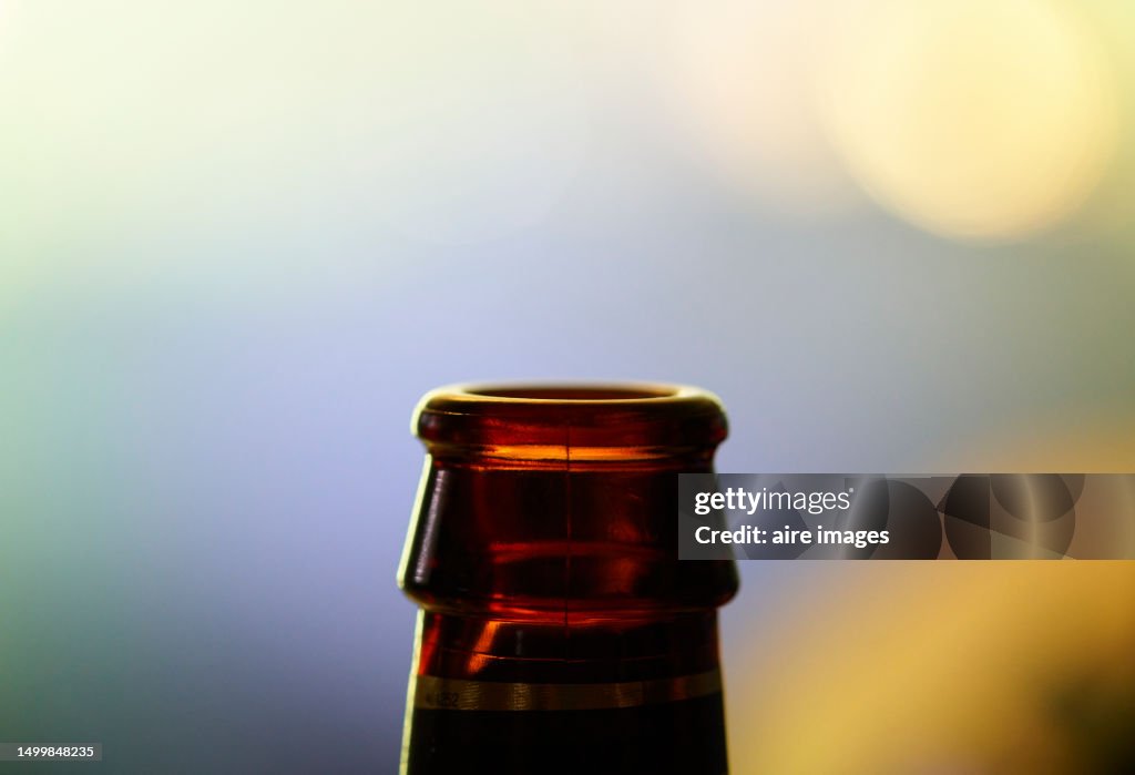 Close-up of the spout of an empty beer bottle opened at some event without people, front view