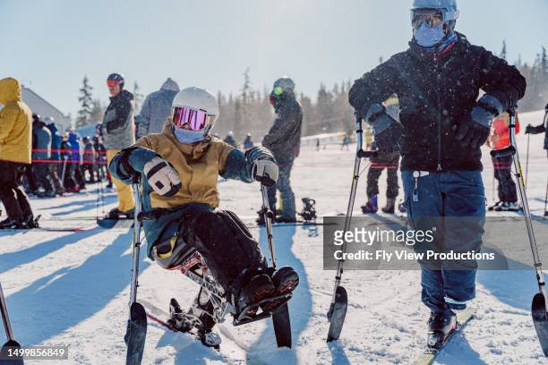 two adaptive athletes enjoying a day on the mountain together - disabilitycollection stock pictures, royalty-free photos & images