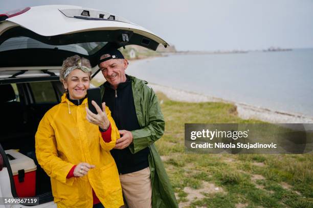 senior couple taking a selfie at the beach - men selfie wide stock pictures, royalty-free photos & images