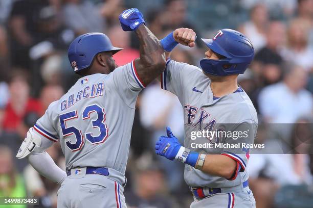 Josh Jung of the Texas Rangers celebrates a solo home run with Adolis Garcia against the Chicago White Sox during the third inning at Guaranteed Rate...