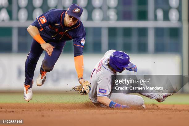 Jeff McNeil of the New York Mets steals second ahead of Jeremy Pena but advances to third on the throwing error from Martin Maldonado of the Houston...