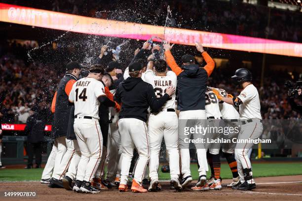 Mike Yastrzemski of the San Francisco Giants celebrates with teammates after hitting a walk-off three-run home run in the bottom of the tenth inning...