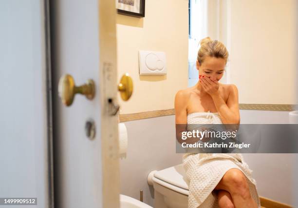 woman reacting to pregnancy test result, covering her mouth - lazio medical tests stock pictures, royalty-free photos & images