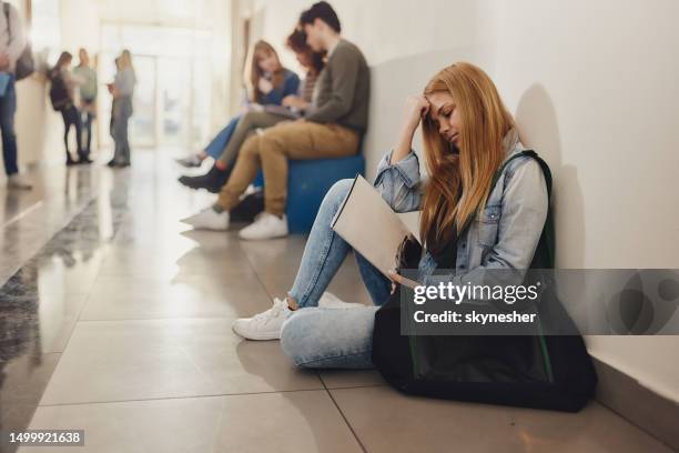 female student relaxing on floor during a break in a hallway. - secondary student thinking stock pictures, royalty-free photos & images