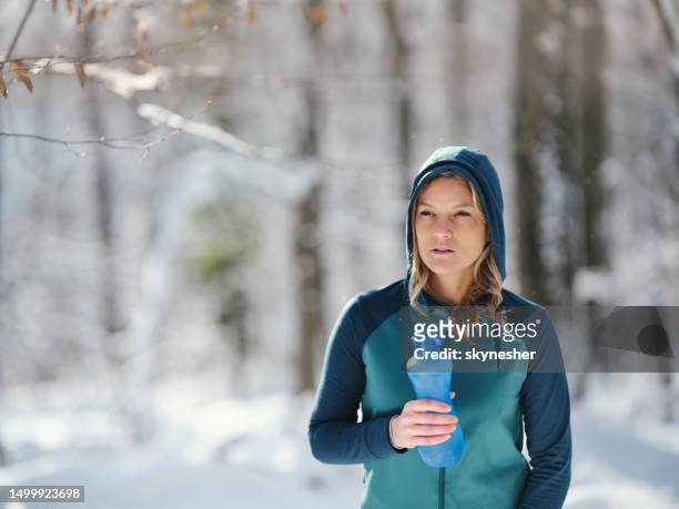 athletic woman having a water break in winter day. - groyne stock pictures, royalty-free photos & images