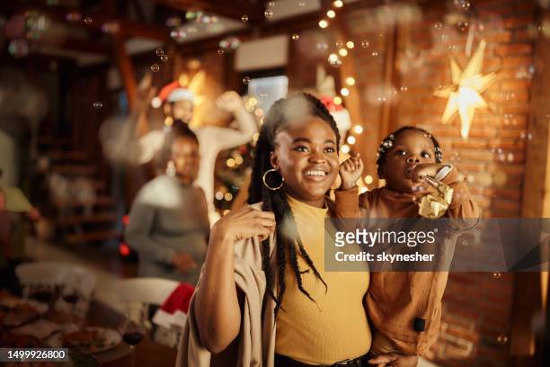 happy african american mother and son celebrating christmas at home. - family new year's eve stock pictures, royalty-free photos & images