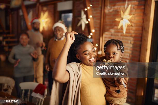 happy black mother and son having fun during new year's party in dining room. - christmas fun stock pictures, royalty-free photos & images