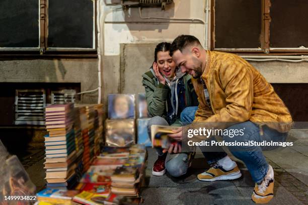 el amor compartido de la joven pareja por los libros antiguos y los discos de música brilla a través de - romance book covers fotografías e imágenes de stock