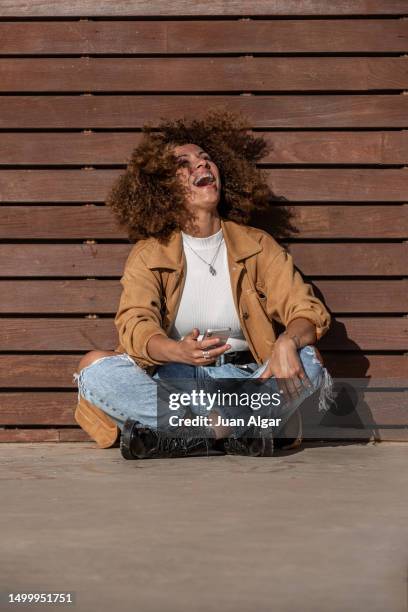 hispanic woman with cellphone laughing at joke - summer sounds stock pictures, royalty-free photos & images