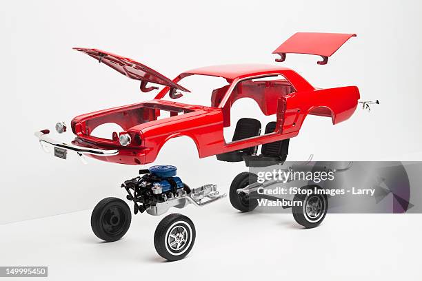 a model car taking a part, some pieces in mid-air - auto zerlegt stock-fotos und bilder