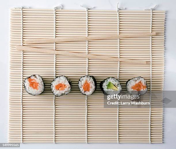 sushi and chopsticks on a wooden mat - maki sushi stockfoto's en -beelden