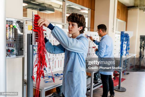 students working on electrical circuit board - engeneer student electronics stock pictures, royalty-free photos & images