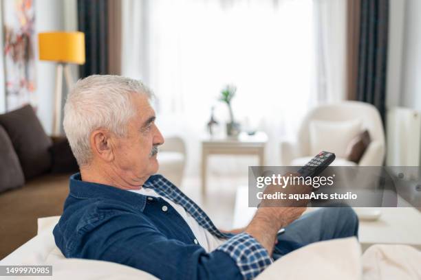 homem sênior gosta de assistir televisão em casa - television studio - fotografias e filmes do acervo