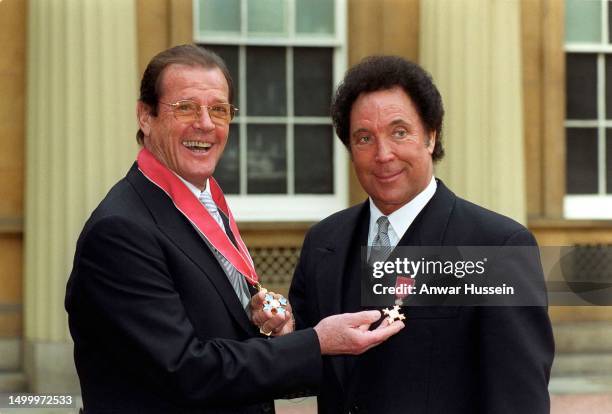 James Bond actor Roger Moore and Welsh singer Tom Jones at Buckingham Palace after they each received honours from the Queen. On March 09, 1999 in...