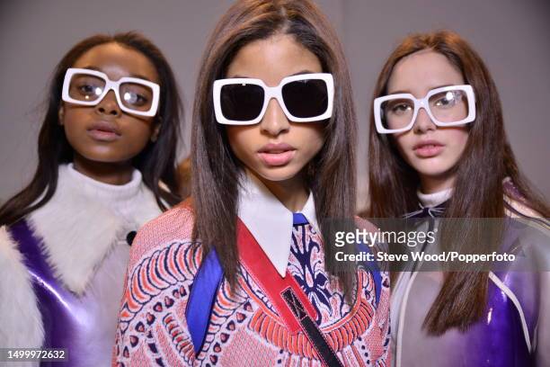Backstage at the Custo Barcelona show during New York Fashion Week Autumn/Winter 2016/17, two models wear coats in glossy metallic fabric, one with...