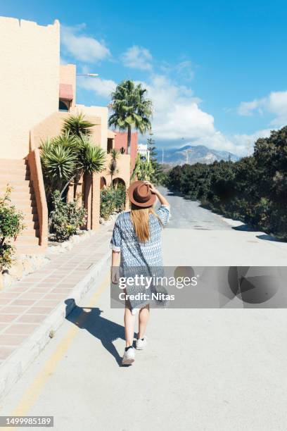 rearview of young blonde explorer female in tropical area - back to front stock pictures, royalty-free photos & images