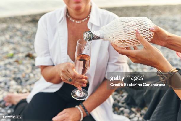 woman pouring pink champagne into glass - gin tasting stock pictures, royalty-free photos & images