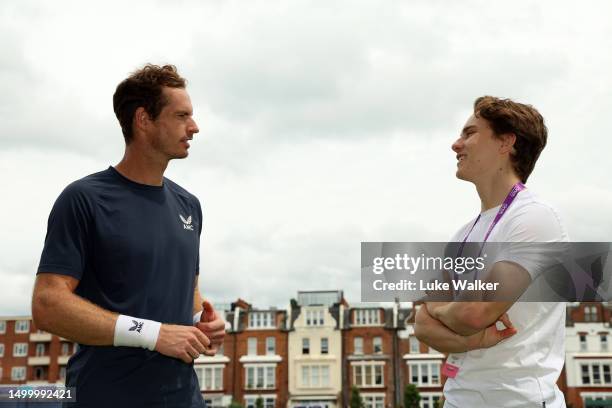 Andy Murray of Great Britain speaks with Oscar Piastri, McLaren Formula 1 driver on Day Two of the cinch Championships at The Queen's Club on June...