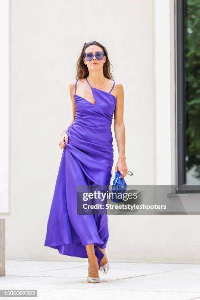 Influencer Anna von Schilcher, wearing a purple colored long dress by The Artico, a blue sequined bag by Dries van Noten, jewelry by Strawberry and...