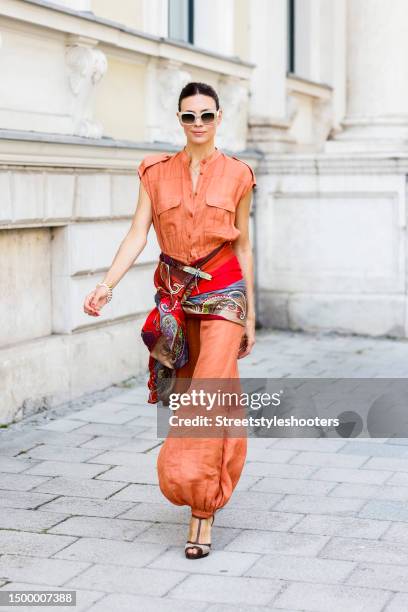 Influencer Anna von Schilcher, wearing a orange colored jumpsuit by Loro Piana, a scarf by Etro, jewelry by Strawberry and cream and sunglasses by...