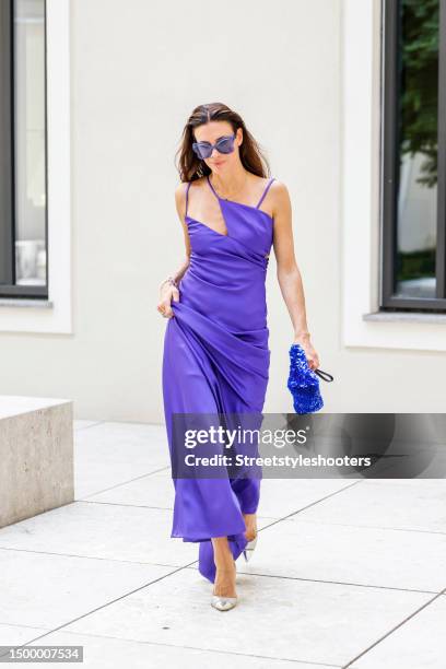 Influencer Anna von Schilcher, wearing a purple colored long dress by The Artico, a blue sequined bag by Dries van Noten, jewelry by Strawberry and...