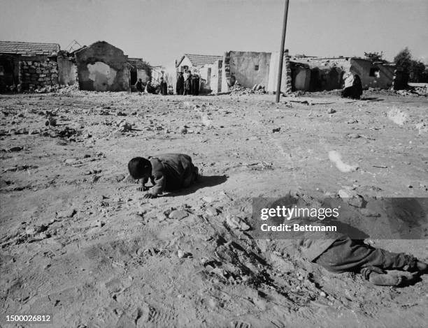 One child plays in the dirt while another lies down in the bright sunlight at the Rafah refugee camp in the Gaza Strip, January 25th 1973.