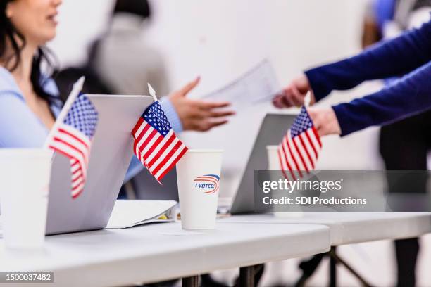 voluntaria del lugar de votación reparte boletas a los votantes irreconocibles - elección general fotografías e imágenes de stock