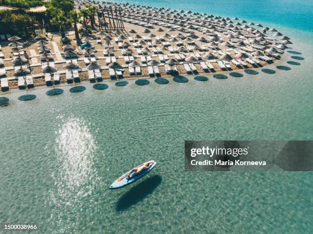 woman sunbathing on stand up paddle board view from above. - blue lagoon imagens e fotografias de stock