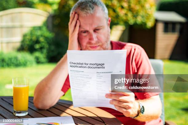 man reading mortgage application documents - mortgage document stock pictures, royalty-free photos & images