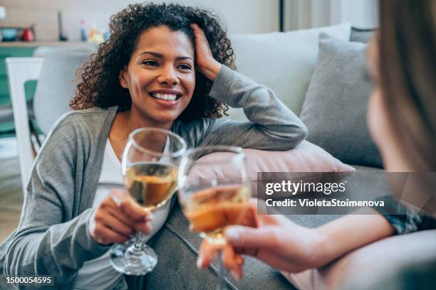 female friends enjoying a glass of wine. - drinking alcohol at home stock pictures, royalty-free photos & images