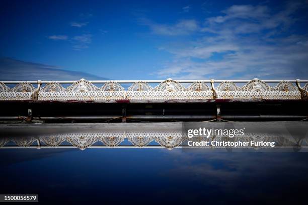 The Victorian cast iron seats are reflected in a rain puddle on Blackpool's iconic North Pier as the Lancashire seaside resort gears up for the...