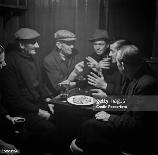 Local fishermen, from left, George Harris, Fred Bumsted, Charlie Moon, Alfred Button, Bert Payne and Percy Joy enjoys pints of beer and a plate of...