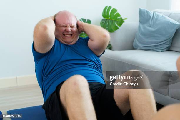 oversized fat man doing a home exercise. - obesity imagens e fotografias de stock