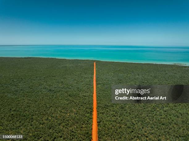 orange coloured dirt road heading towards the indian ocean photographed from an aerial perspective on a sunny day, western australia, australia - road stock pictures, royalty-free photos & images