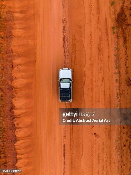 drone perspective showing a 4x4 driving on an orange coloured dirt road, broome, western australia, australia - outback western australia stock pictures, royalty-free photos & images