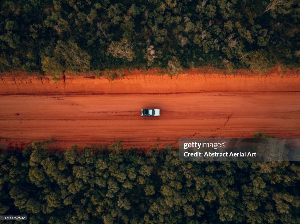 Overhead image showing a 4x4 driving through a forest on a corrugated dirt road, Dampier Peninsula, Western Australia, Australia