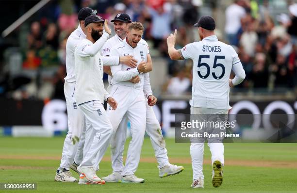 Joe Root of England is congratulated by James Anderson, Ben Stokes and Moeen Ali of England after taking the wicket of Alex Carey of Australia,...