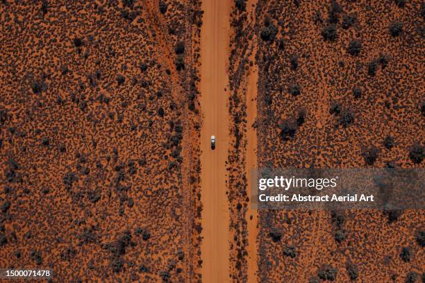 overhead shot showing a 4x4 driving on an orange coloured road in the australian outback, northern territory, australia - wilderness road stock pictures, royalty-free photos & images