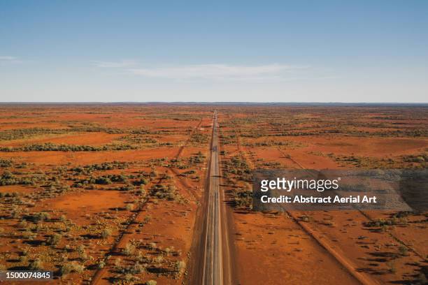 aerial photo showing a highway crossing through a barren landscape in the australian outback, western australia, australia - western australia road stock pictures, royalty-free photos & images