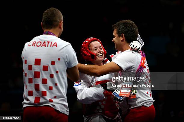 Lucija Zaninovic of Croatia celebrates with her coaching staff after winning the bronze medal in the Women's -49kg Taekwondo bronze medal match...