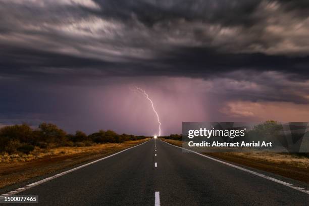 low angle shot looking down the centre of a highway towards a fork of lightning, western australia, australia - dramatic landscape stock pictures, royalty-free photos & images