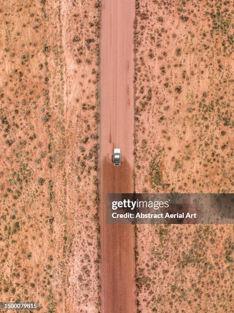 drone image showing a 4x4 driving on a dirt road through a barren landscape, south australia, australia - dirt road stock pictures, royalty-free photos & images