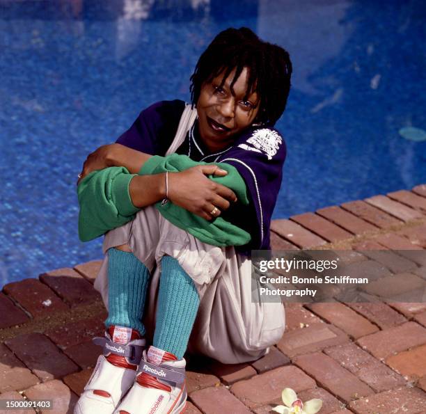 American actress Whoopi Goldberg poses for a portrait sitting next to her swimming pool in Los Angeles, California, March 1986.
