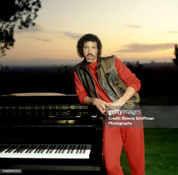 American singer Lionel Richie poses for a portrait with his piano and sunset in Los Angeles, California, circa 1983.
