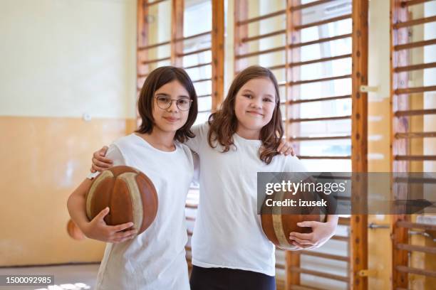 portrait of school girls holding basketball balls - physical education stock pictures, royalty-free photos & images