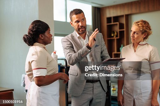 Shift manager explaining procedure to two diverse housekeepers